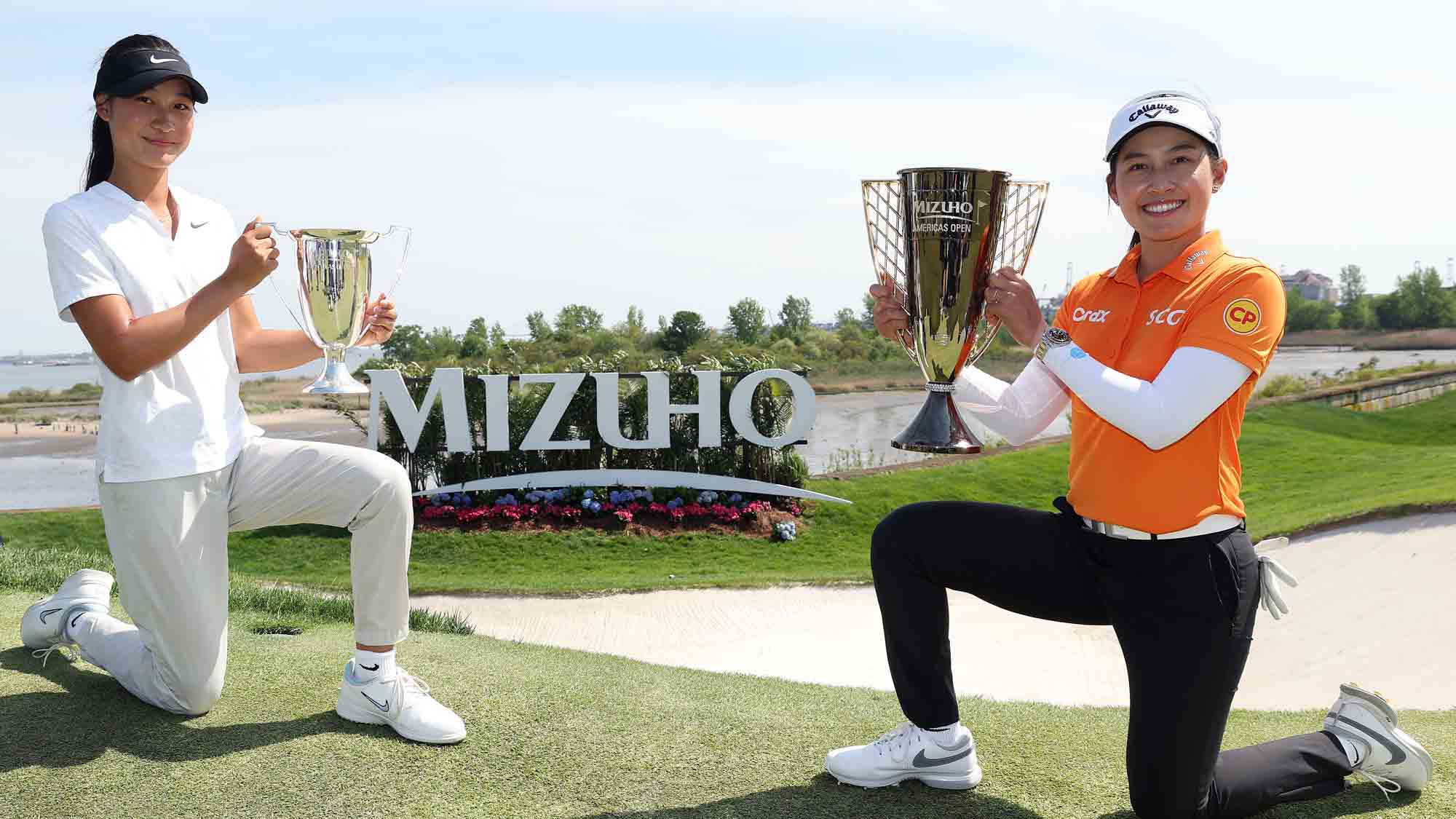 Low amateur Aphrodite Deng of Canada and tournament winner Jeeno Thitikul of Thailand pose with their trophies after the Mizuho Americas Open 2025 at Liberty National Golf Club on May 11, 2025 in Jersey City, New Jersey.