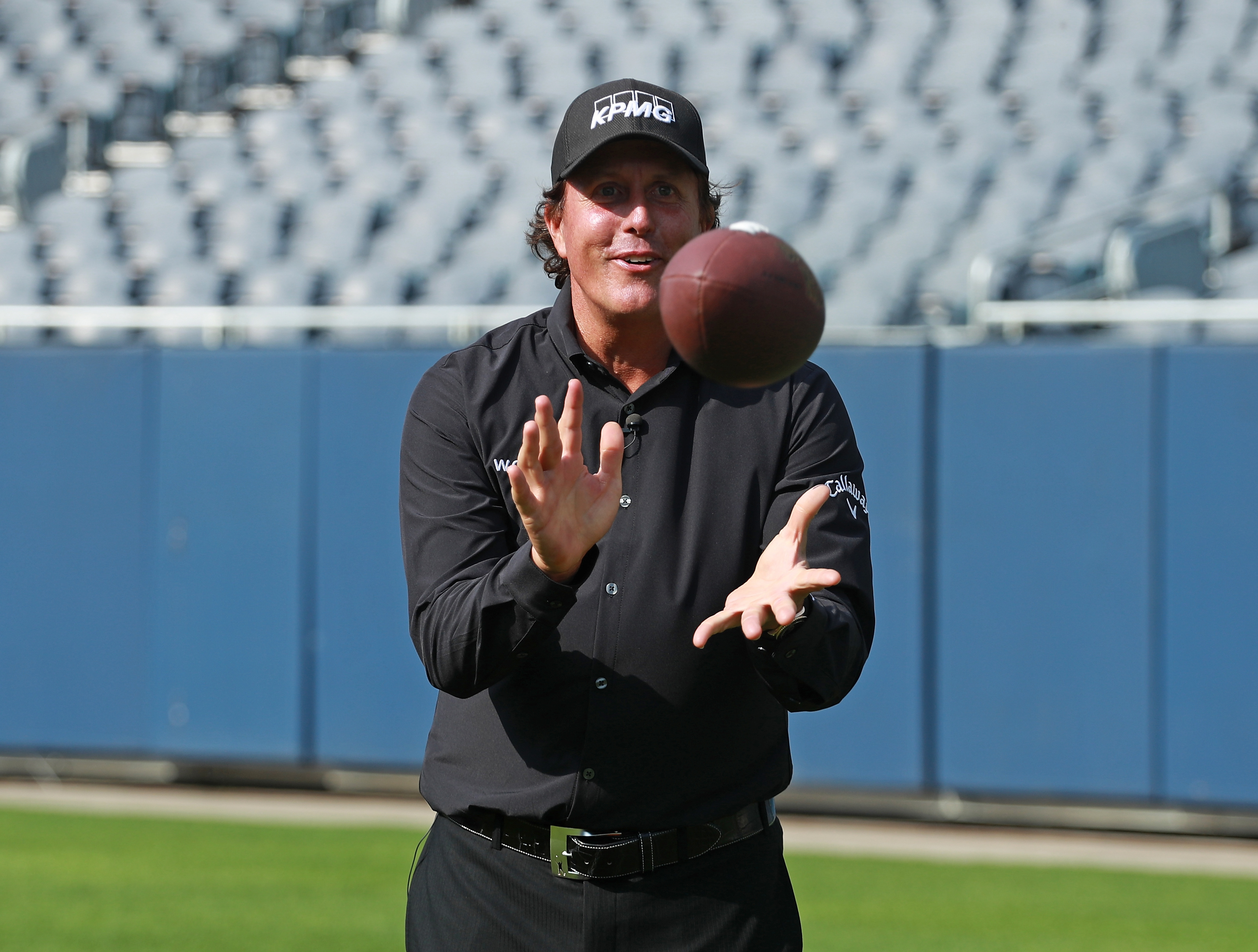 Phil Mickelson catches a football