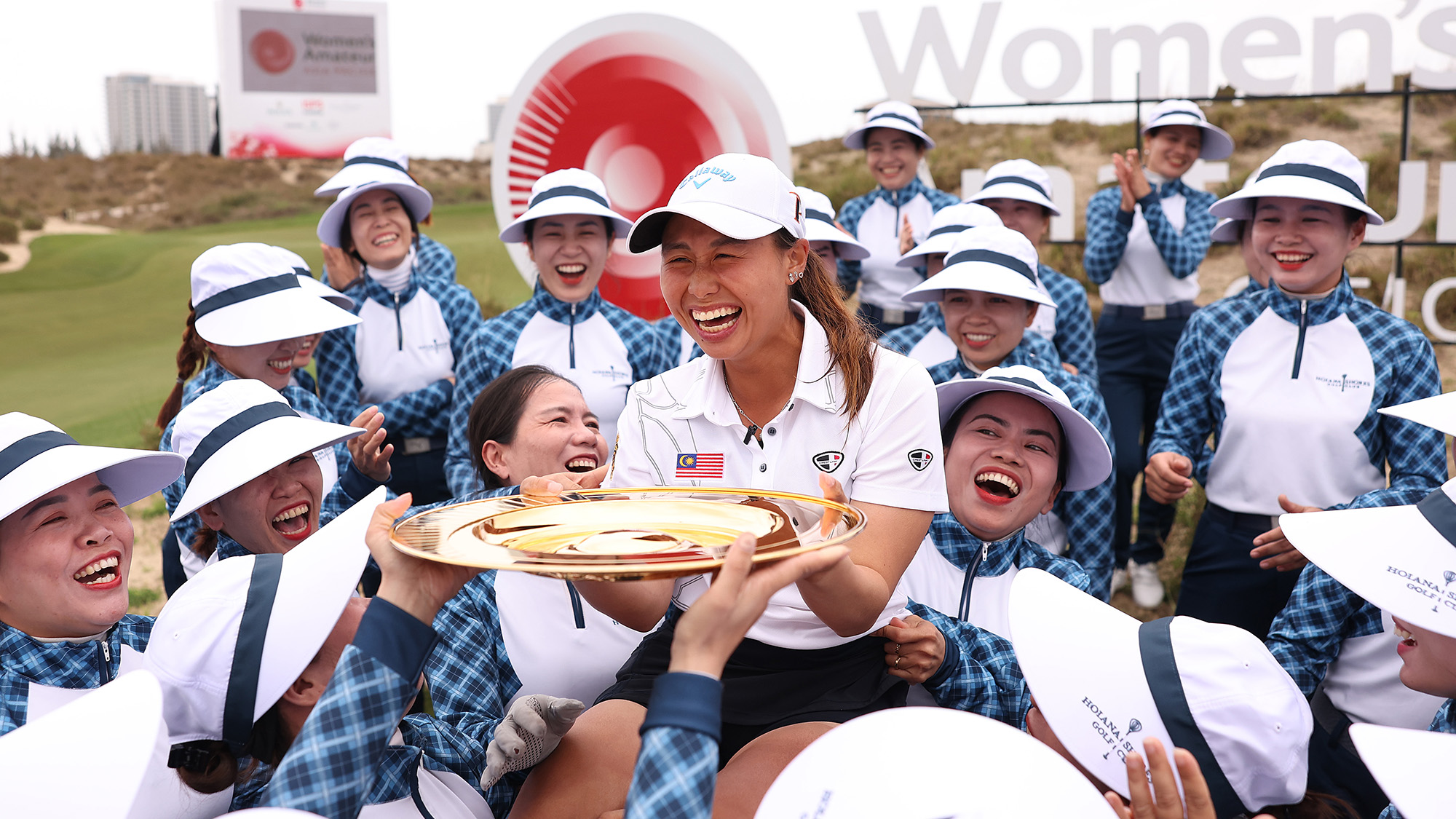 Jeneath Wong of Malaysia is congratulated by the Hoiana Shores Golf Club caddies.