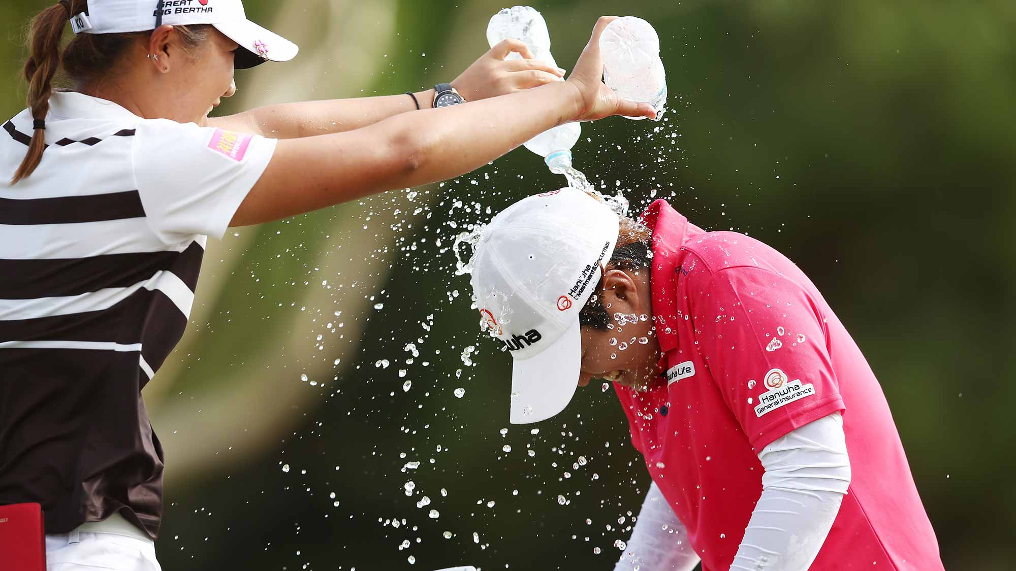 Haru Nomura of Japan runs away from Lydia Ko of New Zealand as Ko tries to dump water on her head in celebration after Nomura won the Women's Australian Open