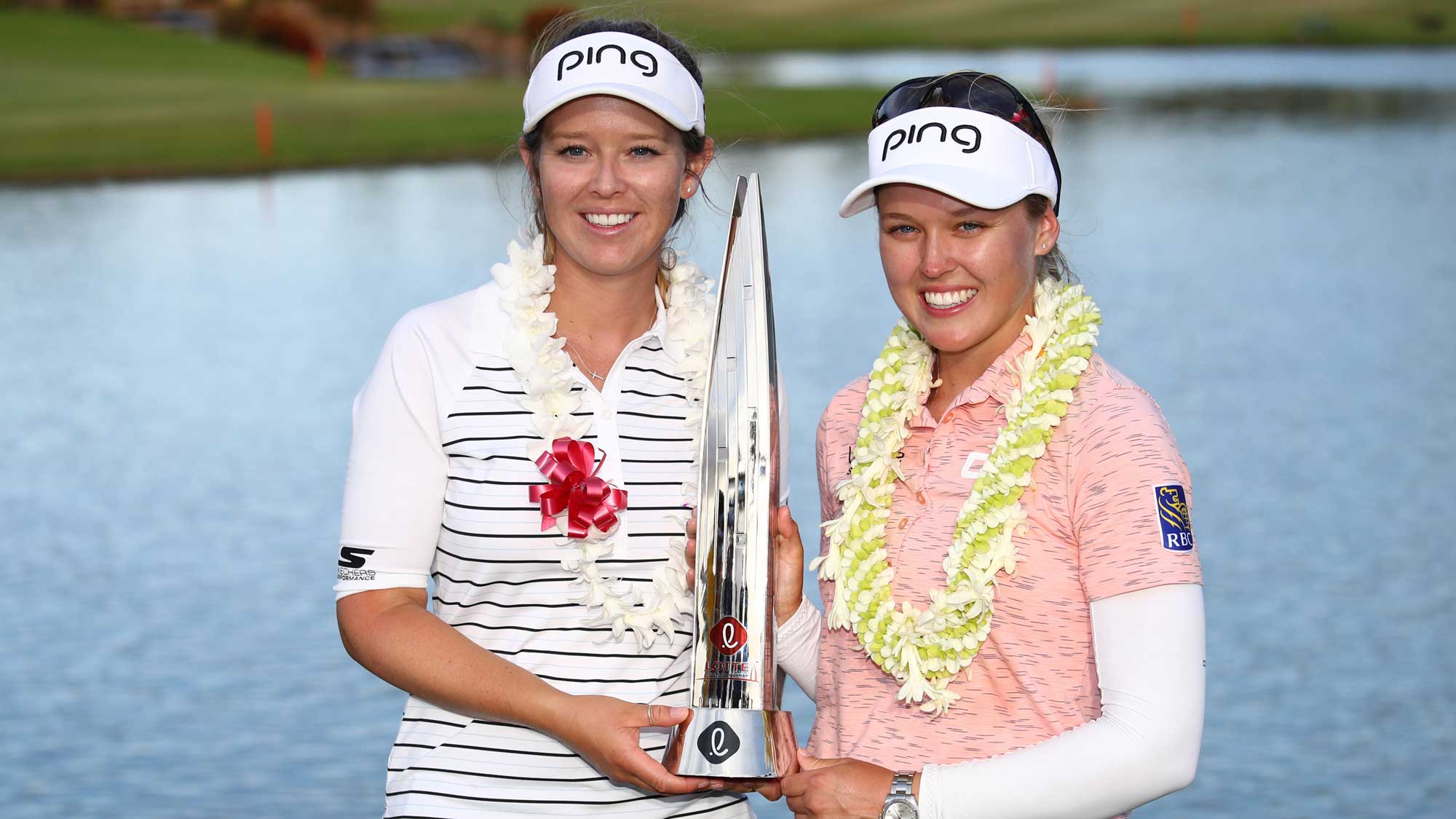 Brooke Henderson celebrates with the traphy after winning the LOTTE Championship on the 18th green with her sister and caddie Brittney Henderson at Ko Olina Golf Club on April 21, 2019 in Kapolei, Hawaii.